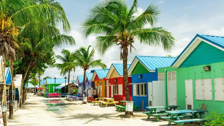 Barbados Bright image of wooden promenade at the waterfront of Bridgetown in Barbados. Colorful building against blue sky with white clouds. Boats and yachts in the harbor.