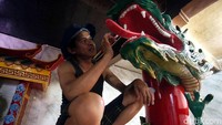 Seorang pekerja sedang mengecat ulang patung naga yang berada di area Klenteng Hok Lay Kiong, Bekasi.