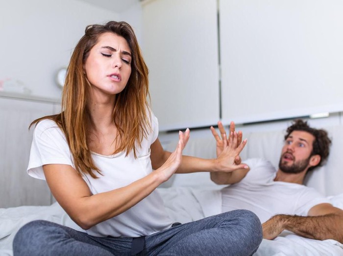 Unhappy housewife sitting near the window