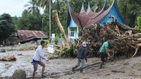 Warga melintas di depan rumah yang rusak diterjang banjir bandang, di Nagari Malalo, Kab.Tanah Datar, Sumatera Barat, Jumat (17/1/2020).