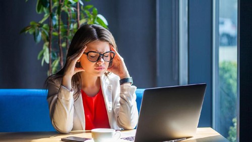 Unhappy housewife sitting near the window