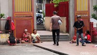 Para pengemis duduk-duduk di depan wihara menantikan jemaat yang selesai ibadah memberikan uang.