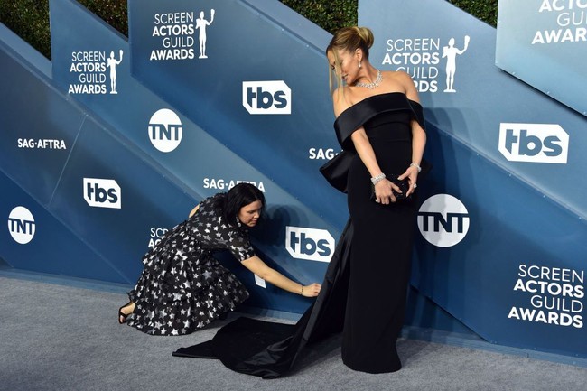 Untuk momen spesial itu, Jennifer Lopez menebar pesonanya dalam balutan gaun midnight blue karya Georges Hobeika. Gaun model off-shoulder itu hadir dalam potongan minimalis yang elegan. (Foto: Jon Kopaloff/Getty Images
