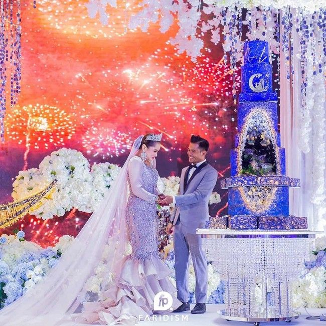 Pernikahan dengan dekorasi semarak tersebut berlangsung di World Trade Centre, Kuala Lumpur.  Salah satu bagian dari pernikahan ELly dan Azlan yang menyedot perhatian adalah kue pernikahan mereka.  Foto: Instagram @iamellymazlein