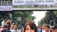 Kerja sambil makan, kenapa nggak? Saat meliput aksi demo, Nadia masih sempat makan gorengan. Foto: Instagram nadiasoekarno
