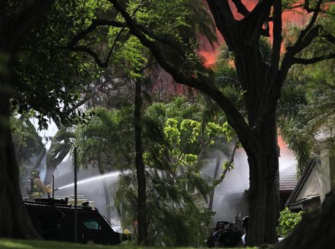 Petugas saat berupaya memadamkan kebakaran yang menyelimuti sebuah rumah yang menjadi lokasi penembakan di Hawaii