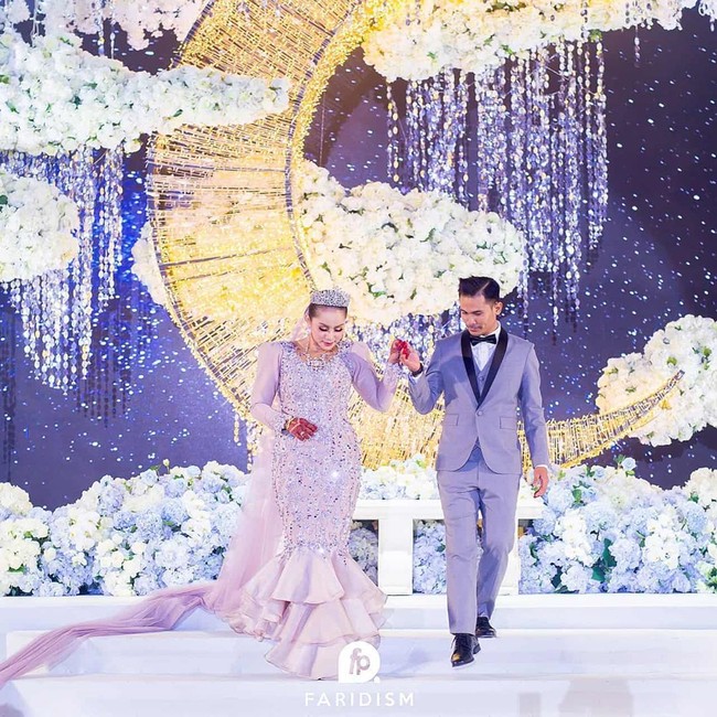 Artis 39 tahun itu tampil cantik dengan dress berpotongan duyung. Sementara sang suami menggunakan setelan jas abu-abu.  Foto: Instagram @iamellymazlein