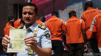Petugas Imigrasi menunjukkan barang bukti paspor yang diamankan dari para WNA.