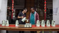 Pramusaji menyajikan teh gratis untuk warga di depan Pantjoran Tea House, Glodok, Jakarta, Selasa (21/1/2020).