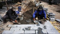 Pekerja mengerjakan proyek revitalisasi trotoar di Jalan RM Margono Djojohadikoesoemo, Jakarta, Selasa (21/1/2020).
