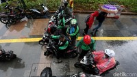 Sejumlah pengendara motor berteduh di pedestrian yang berada di kawasan Jalan MH Thamrin, Jakarta Pusat, saat hujan mengguyur wilayah tersebut, Selasa (21/1/2020).
