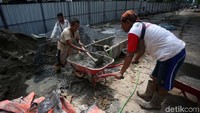 Pekerja membawa adukan semen untuk pembuatan deck view.