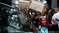 Seorang warga membawa poster bertuliskan Ikan Teri Buah Kedondong Pak Menteri Jangan Shombong!! saat ikut serta dalam aksi unjuk rasa di depan kantor Kemenkum HAM tersebut.