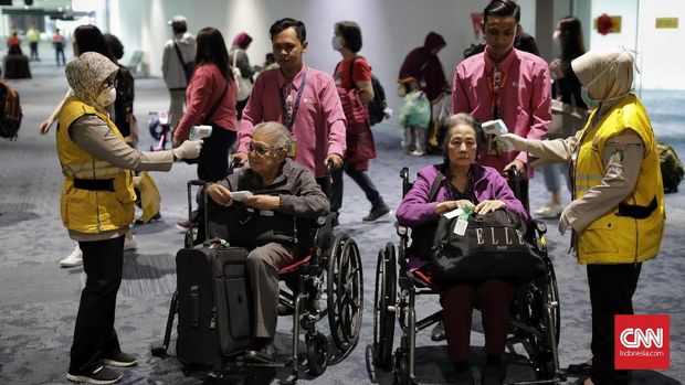 Petugas memantau suhu tubuh penumpang menggunakan alat pemindai suhu tubuh di Terminal Kedatangan Internasional Bandara Internasional Soekarno Hatta. Tangerang, Rabu, 22