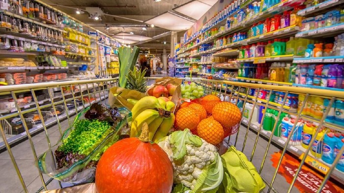 Healthy Fruit and vegetables in Grocery shop cart in supermarket filled with food products as seen from the customers point of view