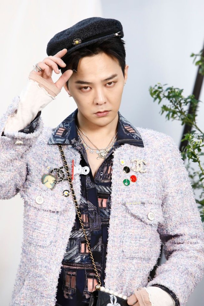 Leader grup Kpop BIGBANG ini mengenakan jaket warna ungu dengan berbagai embellishmet berupa bros dan patch berlogo Chanel. Ia memadukan jaket tersebut dengan kemeja dan celana chino warna navy. Foto: Getty Images