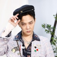 Leader grup Kpop BIGBANG ini mengenakan jaket warna ungu dengan berbagai embellishmet berupa bros dan patch berlogo Chanel. Ia memadukan jaket tersebut dengan kemeja dan celana chino warna navy. Foto: Getty Images