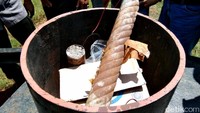 Setelah dibuka, kardus itu berisi pecahan jam analog, lakban untuk pembungkus, kabel, dan 3 buah pipa.