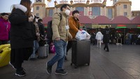 Para penumpang di Stasiun Kereta Beijing memakai masker untuk mengantisipasi terinfeksi virus corona. AP Photo/Mark Schiefelbein.