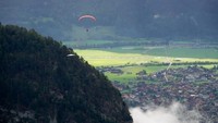 Gursky berlibur di Interlaken, Swiss, bersama istrinya. ursky menggantung lebih dari dua menit di salah satu rangka gantole dan tubuh instrukturnya. Ia terbang tinggi di atas pepohonan dan berpegangan dengan satu tangan (Foto: Chris Gursky/CNN)