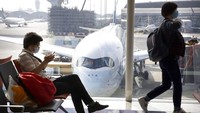 Sejumlah warga Hong Kong mengenakan masker saat menunggu waktu penerbangan untuk mudik menjelang Imlek di Bandara Internasional Hong Kong. AP Photo/Nh Han Guan.