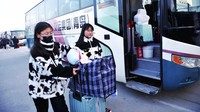 Tak hanya di bandara maupun di stasiun, warga yang mudik dengan menggunakan bus pun juga turut mengenakan masker untuk mengantisipasi terjangkit penyakit akibat virus corona jenis baru tersebut. Chinatopix via AP.