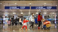 Sejumlah warga mengenakan masker saat hendak mudik ke kampung halaman untuk merayakan Imlek. Virus corona jenis baru yang mulai menyebar ke sejumlah wilayah di China hingga ke luar negeri membuat warga yang tiba di Bandara Beijing, China, mengantisipasi diri agar tak terjangkit penyakit tersebut dengan mengenakan masker. AP Photo/Mark Schiefelbein.