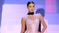 Ia tampil dengan mini dress berwarna cream yang terinspirasi dari busana ikonik Madonna pada 1990an. Pascal Le Segretain/Getty Images