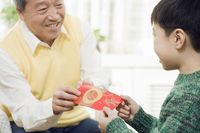 Menerima angpao menggunakan dua tangan.