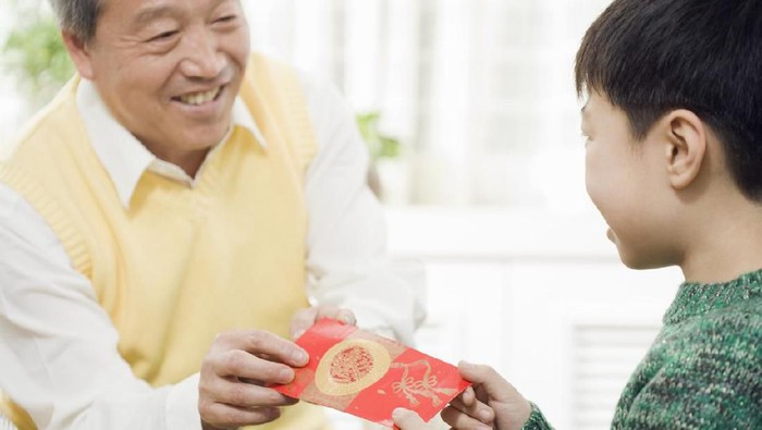 Chinese grandfather giving grandson red pocket