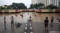 Anak-anak bermain di area banjir underpass Kemayoran, Jakarta, Jumat (24/1/2020).