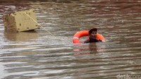 Petugas PPSU dikerahkan untuk membersihkan sampah di underpass yang terendam banjir.