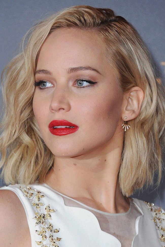 Padanan lipstik merah dan eyeliner cat-eye tidak akan pernah salah. Gaya makeup seperti Jennifer Lawrence ini akan mempercantikan penampilan Imlekmu.  Foto: Getty Images