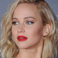 Padanan lipstik merah dan eyeliner cat-eye tidak akan pernah salah. Gaya makeup seperti Jennifer Lawrence ini akan mempercantikan penampilan Imlekmu.  Foto: Getty Images