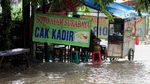 Di Tengah Banjir, Pedagang Ini Tetap Jualan demi Cuan