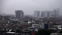 Gedung-gedung bertingkat terlihat samar-samar akibat hujan deras.