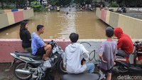 Warga menonton anak-anak berenang sambil ngopi santai.