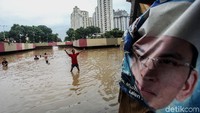 Banjir itu justru dijadikan sejumlah anak untuk bermain.