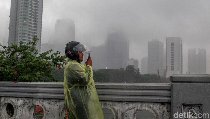 Hujan yang mengguyur berbagai wilayah di Jakarta sejak pagi membuat gedung-gedung pencakar langit di ibu kota tertutup kabut. Yuk, lihat potretnya.