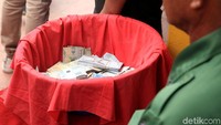Angpao yang diberikan umat ditampung di sebuah wadah sebelum dibagikan kepada warga dan pengemis.