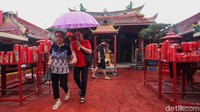 Hujan tak menyurutkan niat warga untuk berdoa di Wihara Boen Tek Bio. Mereka datang ke wihara dengan menggunakan payung.