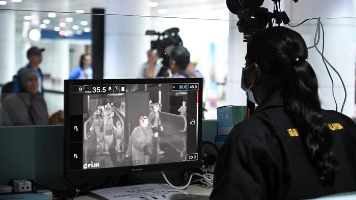 Seorang petugas kesehatan di Malaysia mengawasi setiap penumpang yang baru mendarat di Kuala Lumpur dengan thermal scanner A Malaysian health officer screens arriving passengers with a thermal scanner at Kuala Lumpur International Airport in Sepang on January 21, 2020 as authorities increased measure against coronavirus. - China has confirmed human-to-human transmission in the outbreak of a new SARS-like virus as the number of cases soared and authorities January 21 said a fourth person had died, as the World Health Organization said it would consider declaring an international public health emergency over the outbreak. (Photo by MOHD RASFAN / AFP)