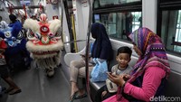 Barongsai beraksi dari satu gerbong ke gerbong lainnya demi untuk menghibur penumpang.