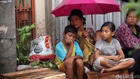 Sambil menggendong seorang anak, mereka rela menunggu hingga berjam-jam.