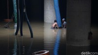 Petugas terus berusaha memompa air yang menggenangi underpass Kemayoran, Minggu (26/1).