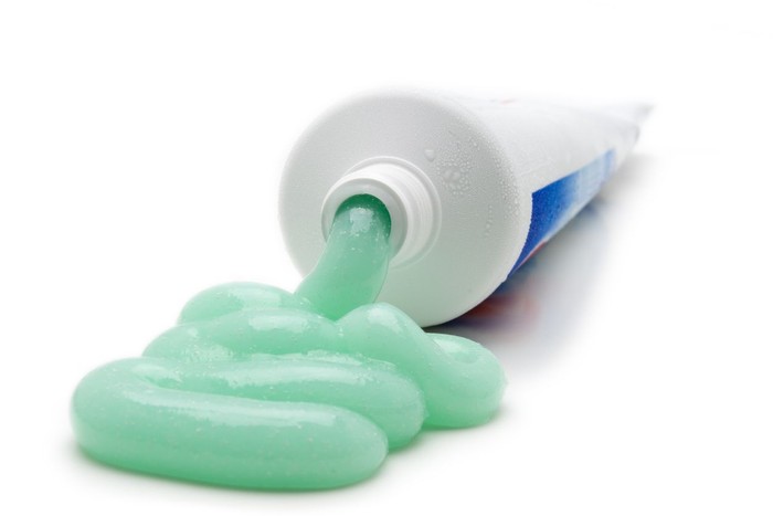 Toothpaste cascades from the tube.