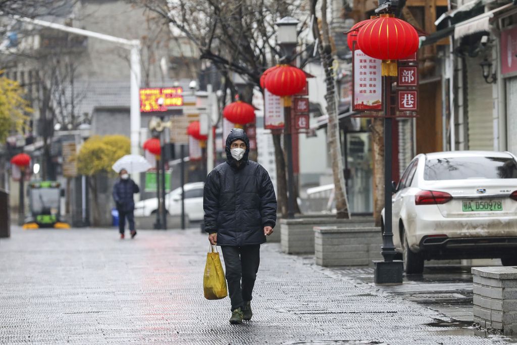 Shoppers wearing face masks look for groceries with many empty shelves at a supermarket in Wuhan in central China's Hubei province, Saturday, Jan. 25, 2020. The virus-hit Chinese city of Wuhan, already on lockdown, banned most vehicle use downtown and Hong Kong said it would close schools for two weeks as authorities scrambled Saturday to stop the spread of an illness that is known to have infected more than 1,200 people and killed 41, according to officials. (Chinatopix via AP)