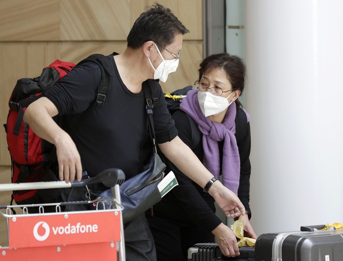 Airport personnel look at thermal scanners as they check on arriving passengers at Manilas international airport, Philippines, Thursday, Jan. 23, 2020. The government is closely monitoring arrival of passengers as a new coronavirus outbreak in Wuhan, China has infected hundreds and caused deaths in that area. (AP Photo/Aaron Favila)