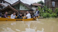Warga menggunakan perahu melintasi banjir yang menggenangi kawasan Baleendah, Kabupaten Bandung, Jawa Barat, Minggu (26/1/2020).
