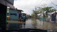 Warga mengevakuasi sepeda motornya agar tidak terendam banjir.